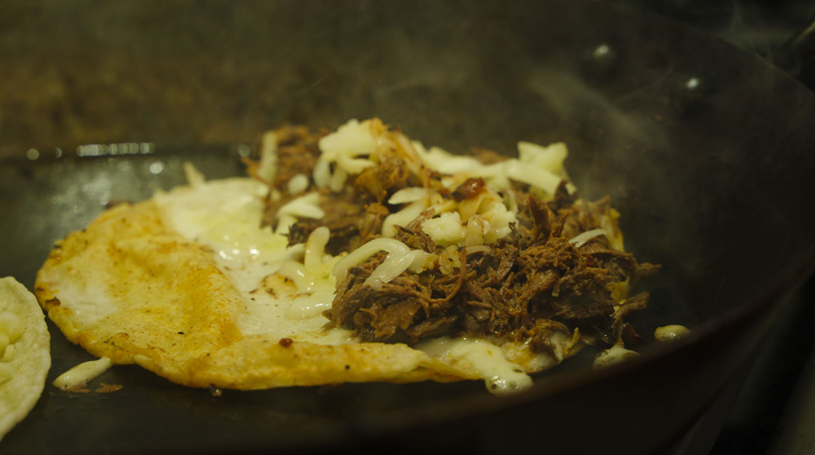 Duck tacos cooking in a pan.