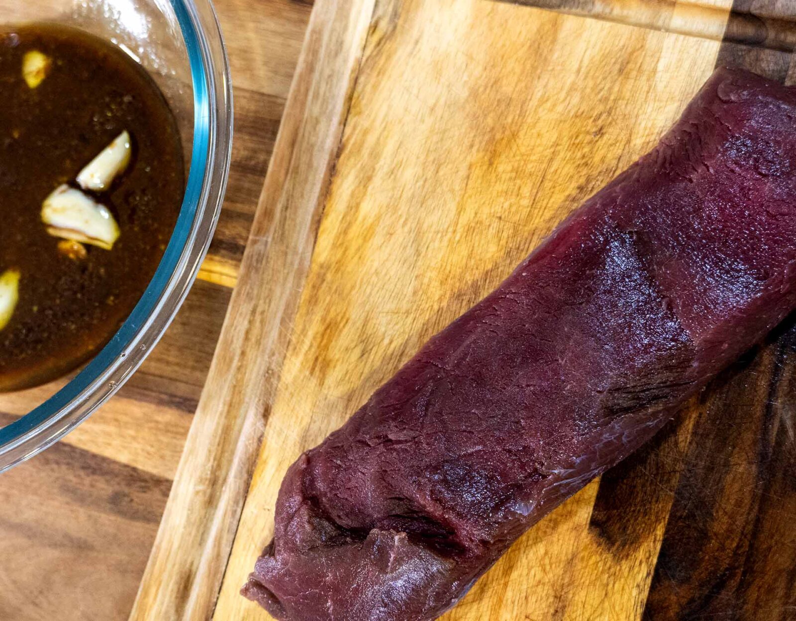 Deer backstrap and a bowl of marinade.