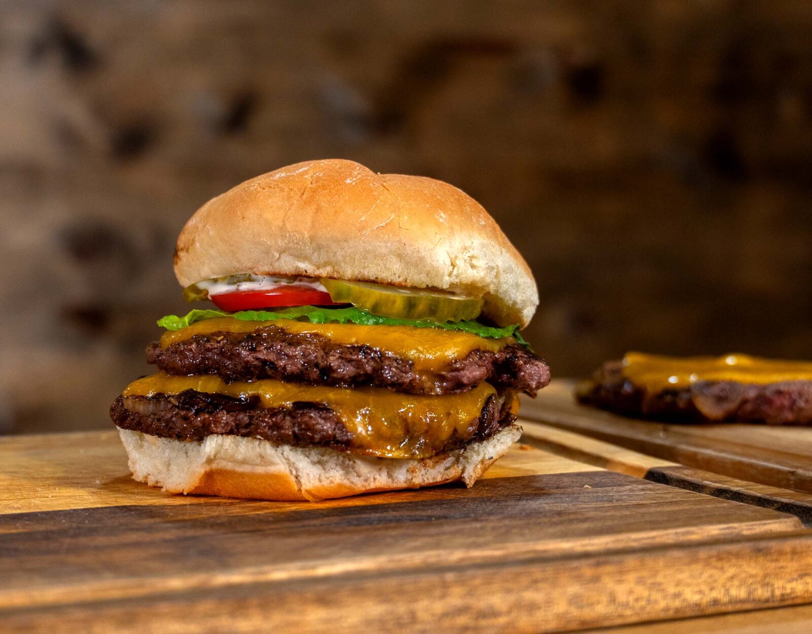 A venison burger on a wooden platter.