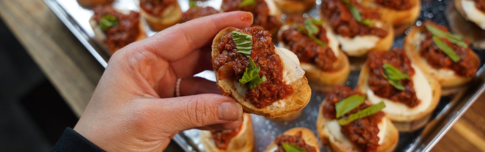 Venison bruschetta held in a hand.