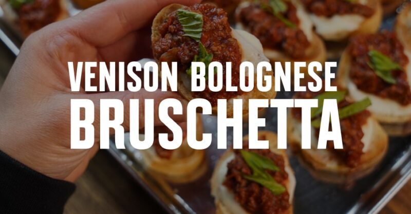 Venison bruschetta held in a hand.