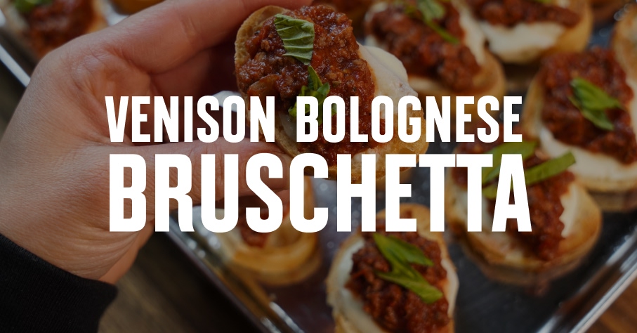 Venison bruschetta held in a hand.
