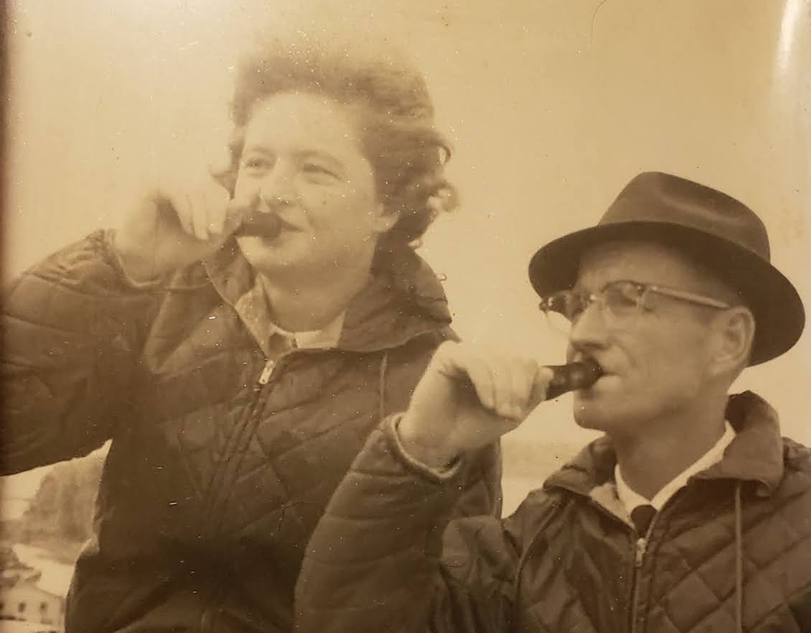 Black and white photo of a man and woman using duck calls.