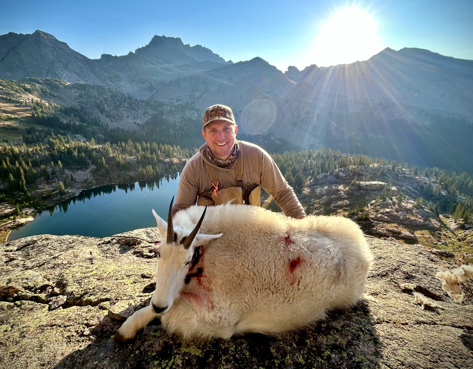 A hunter poses with the mountain goat he harvested.