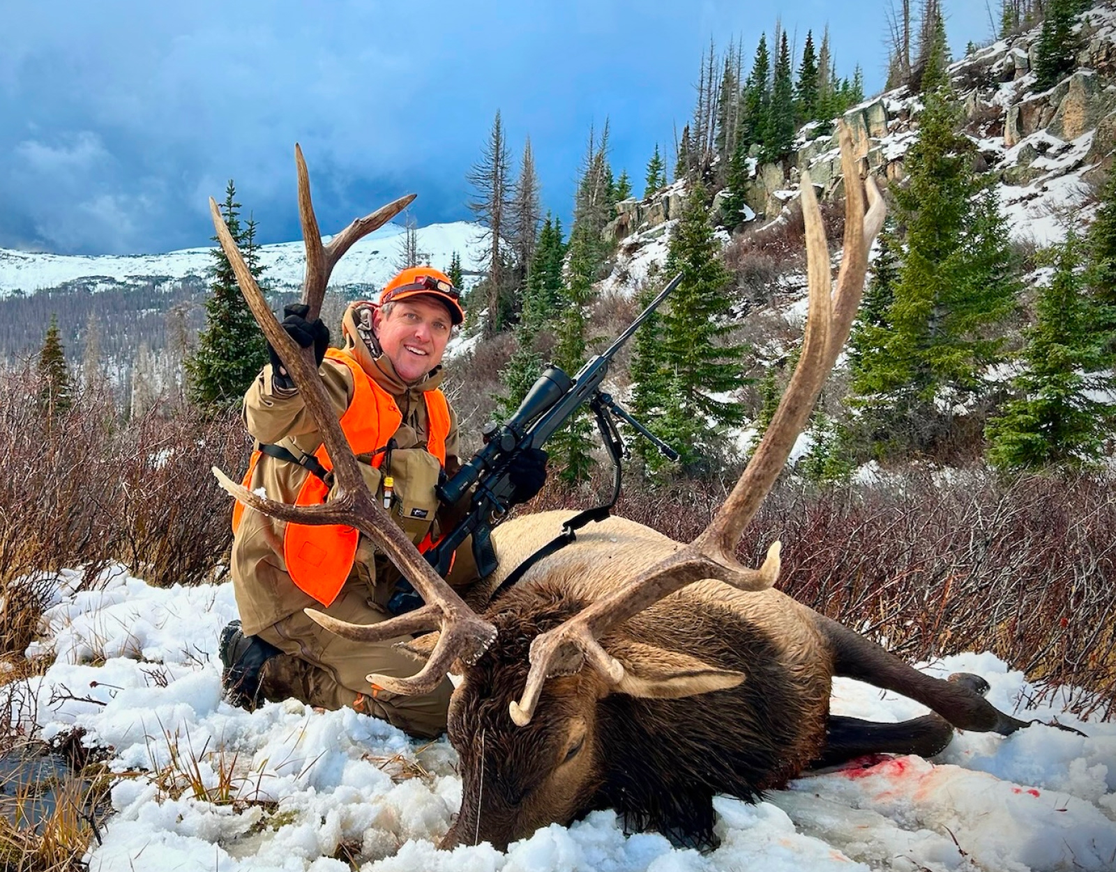 A hunter poses with the bull elk he shot.