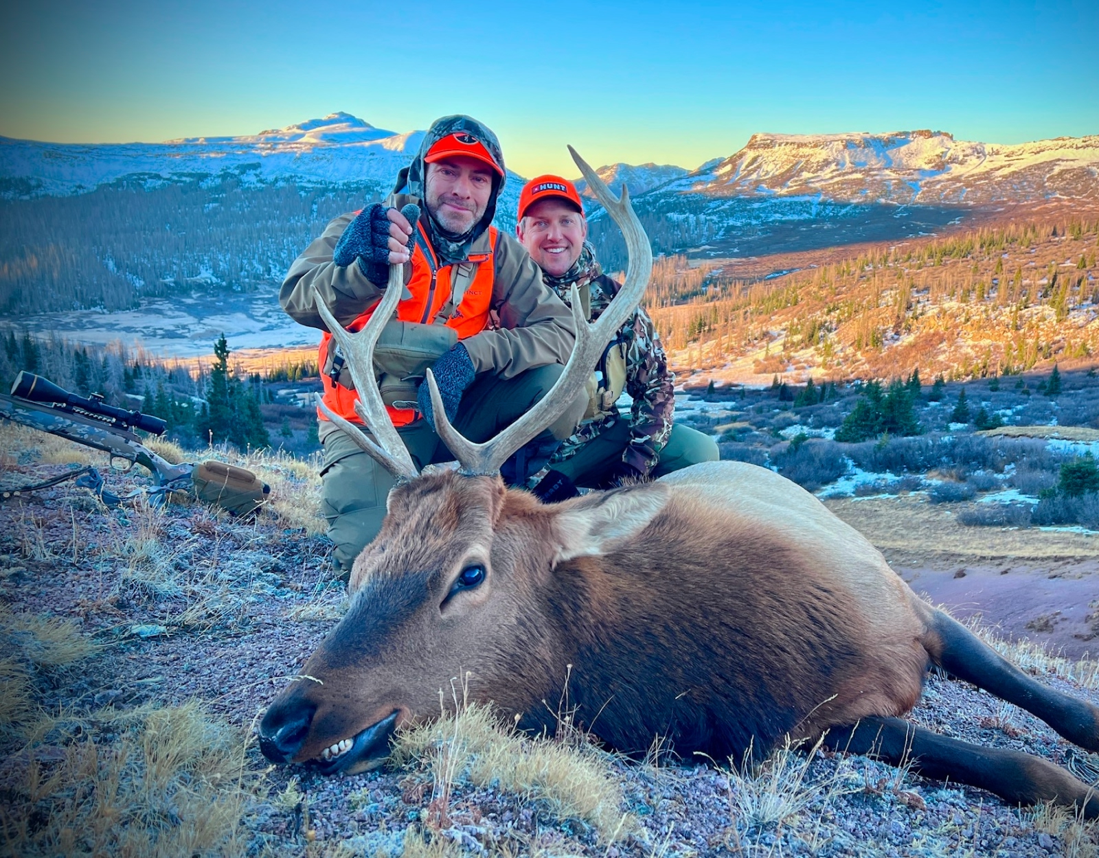A hunter, with his hunting partner, poses with the bull elk he shot.