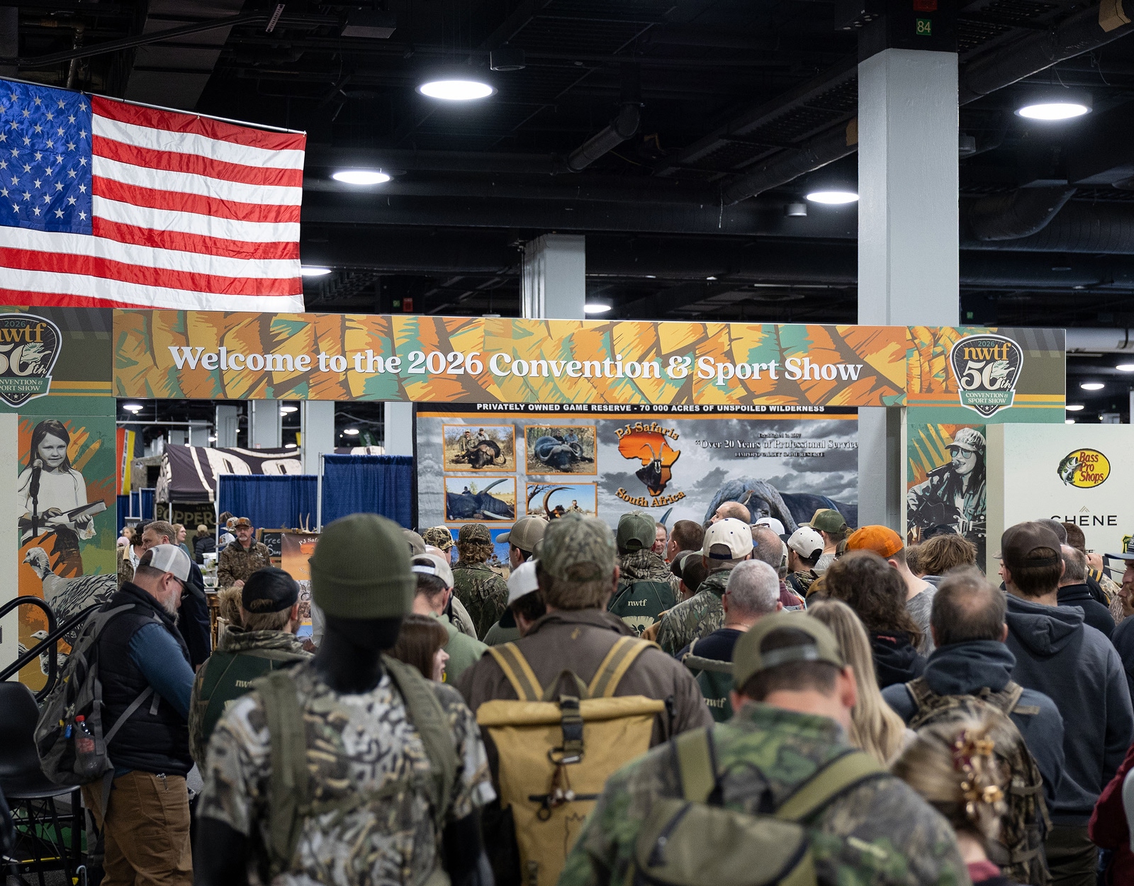 A group of hunters walks through a convention room.