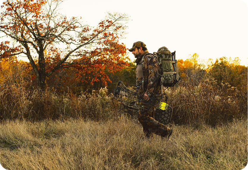A hunter walks through the woods.