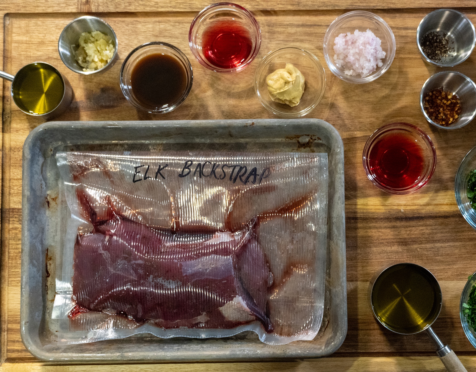 The ingredients for elk steaks with chimichurri sauce laid out on a table