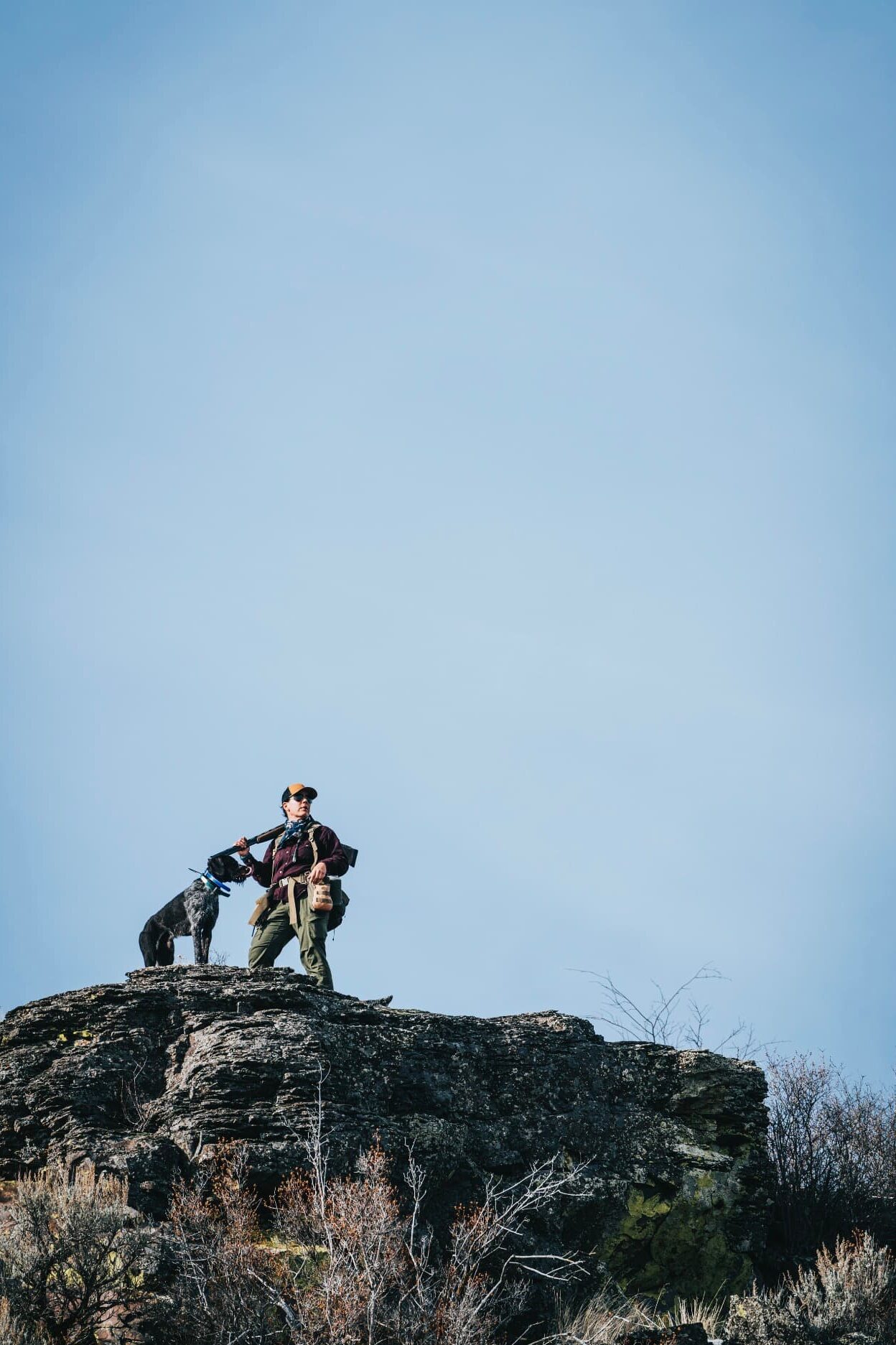A woman upland hunter in the field with her dog
