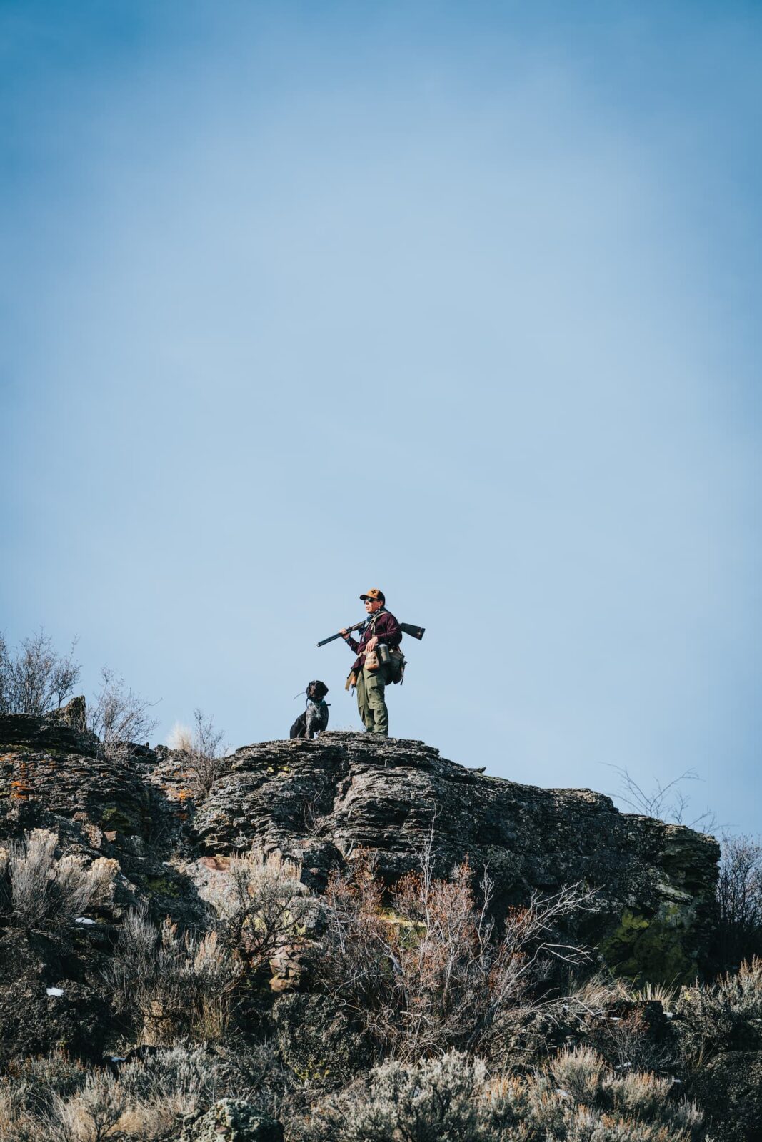 A woman upland hunter in the field with her dog