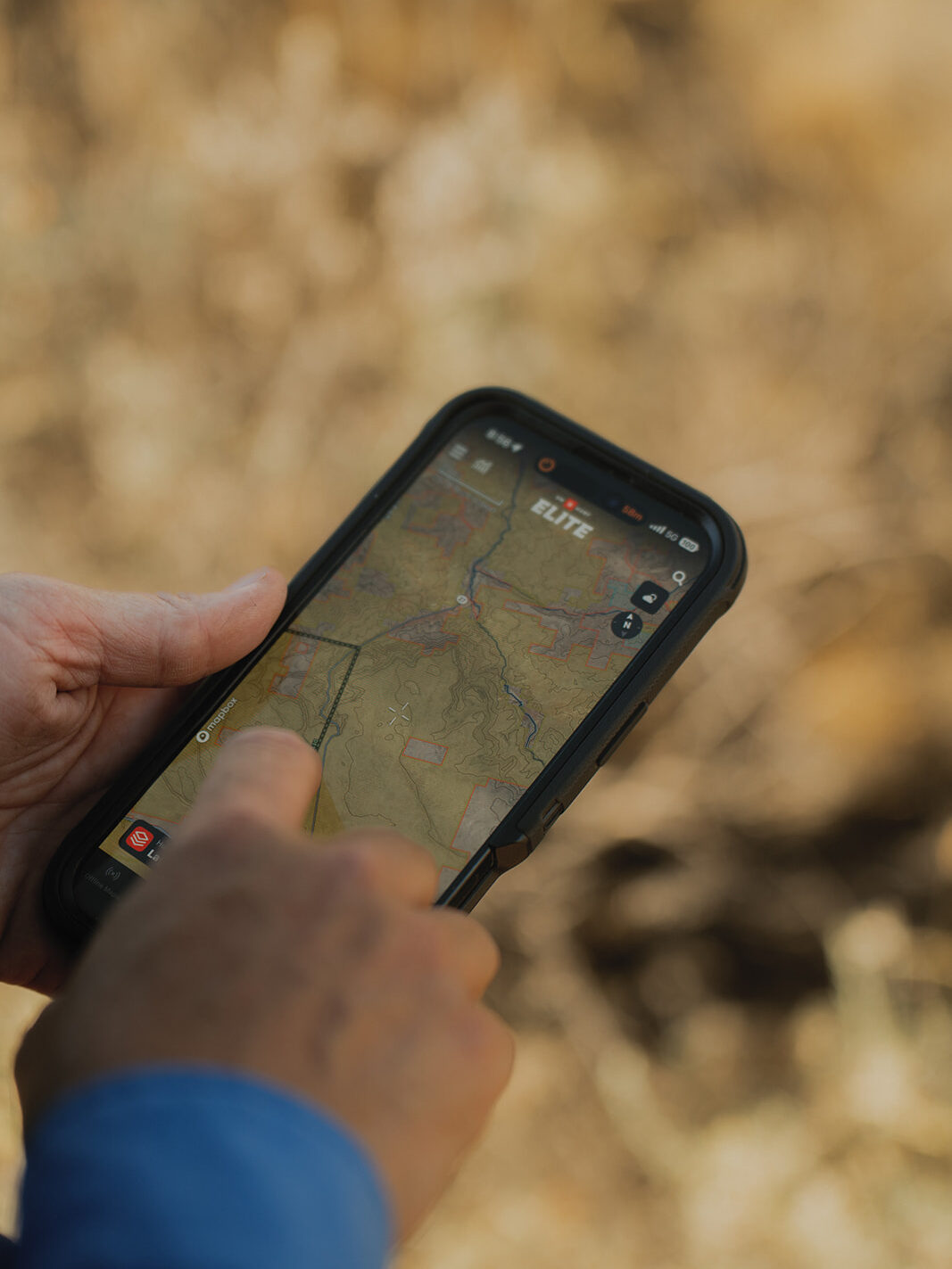 A woman's hand navigates the onX Hunt app on her mobile device.
