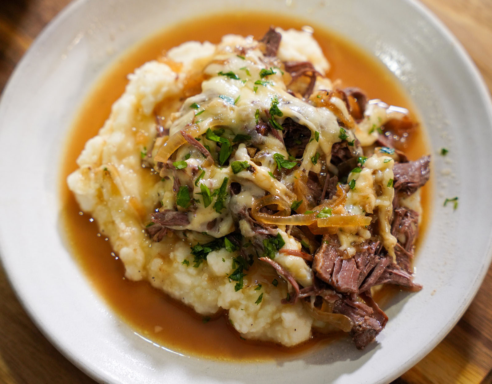 Bear roast plated on a pile of mashed potatoes.