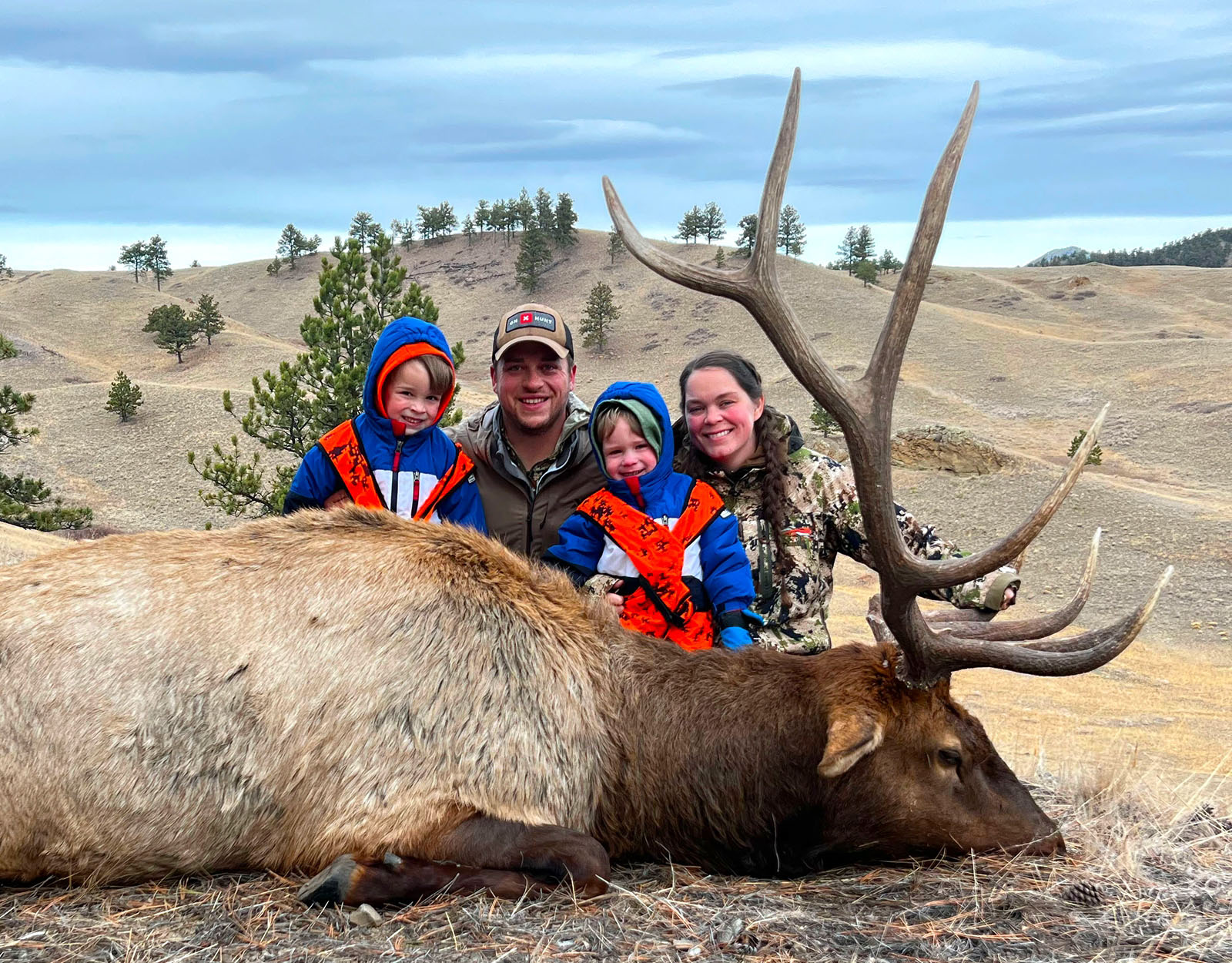 A family poses for a photo with the bull elk one of them harvested.