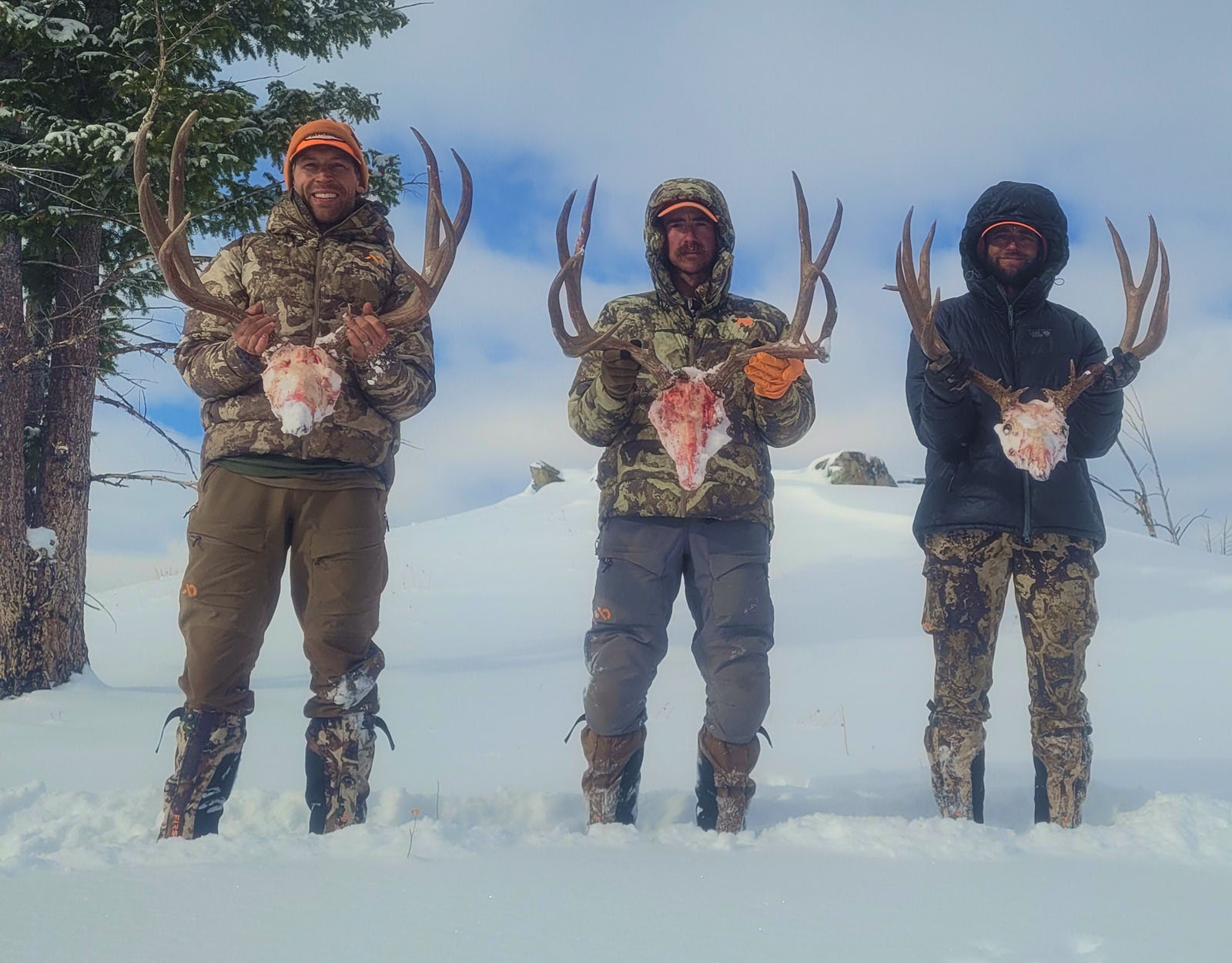 Hunters pose with the mule deer buck they harvested.