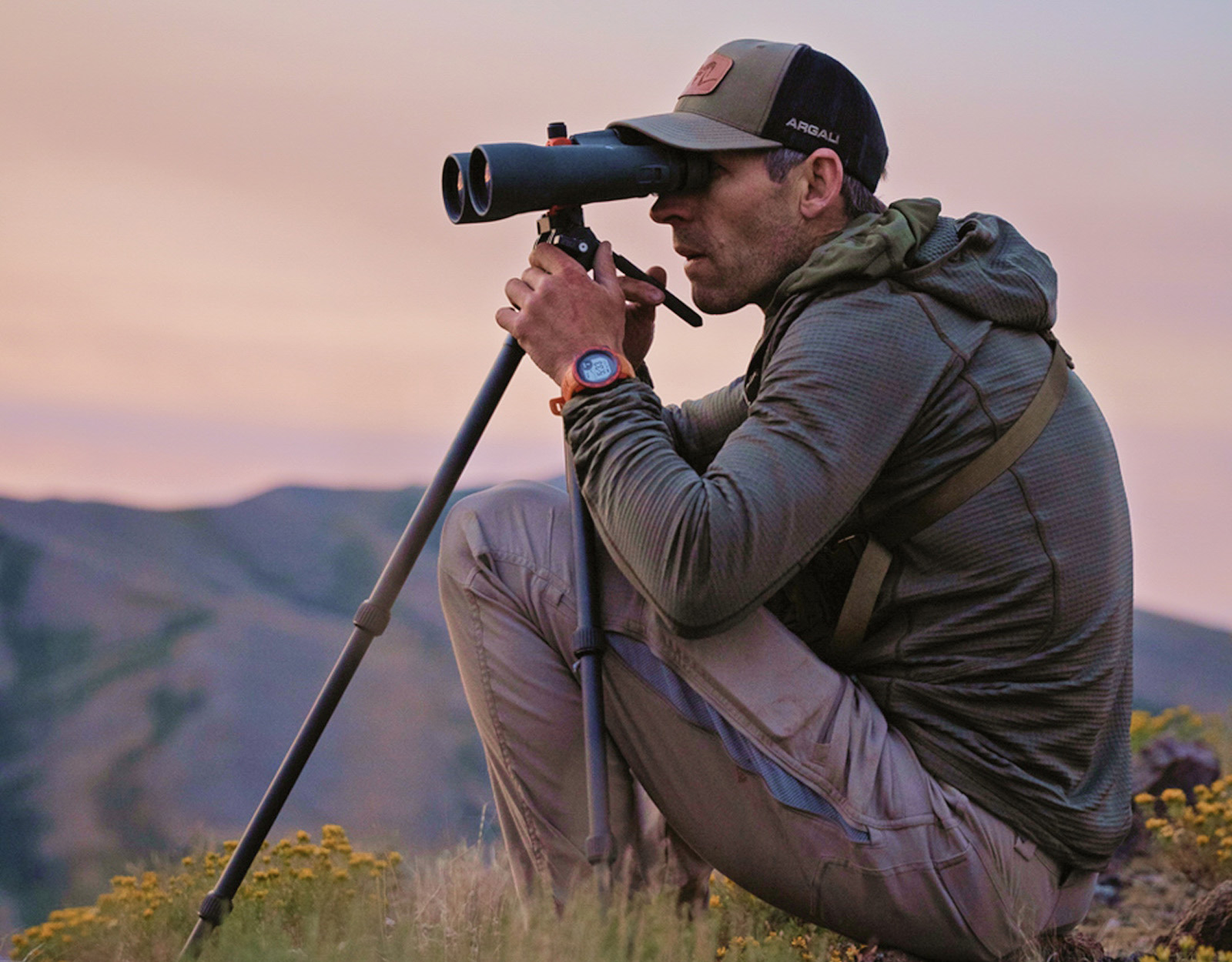 A hunter uses binoculars in the field.