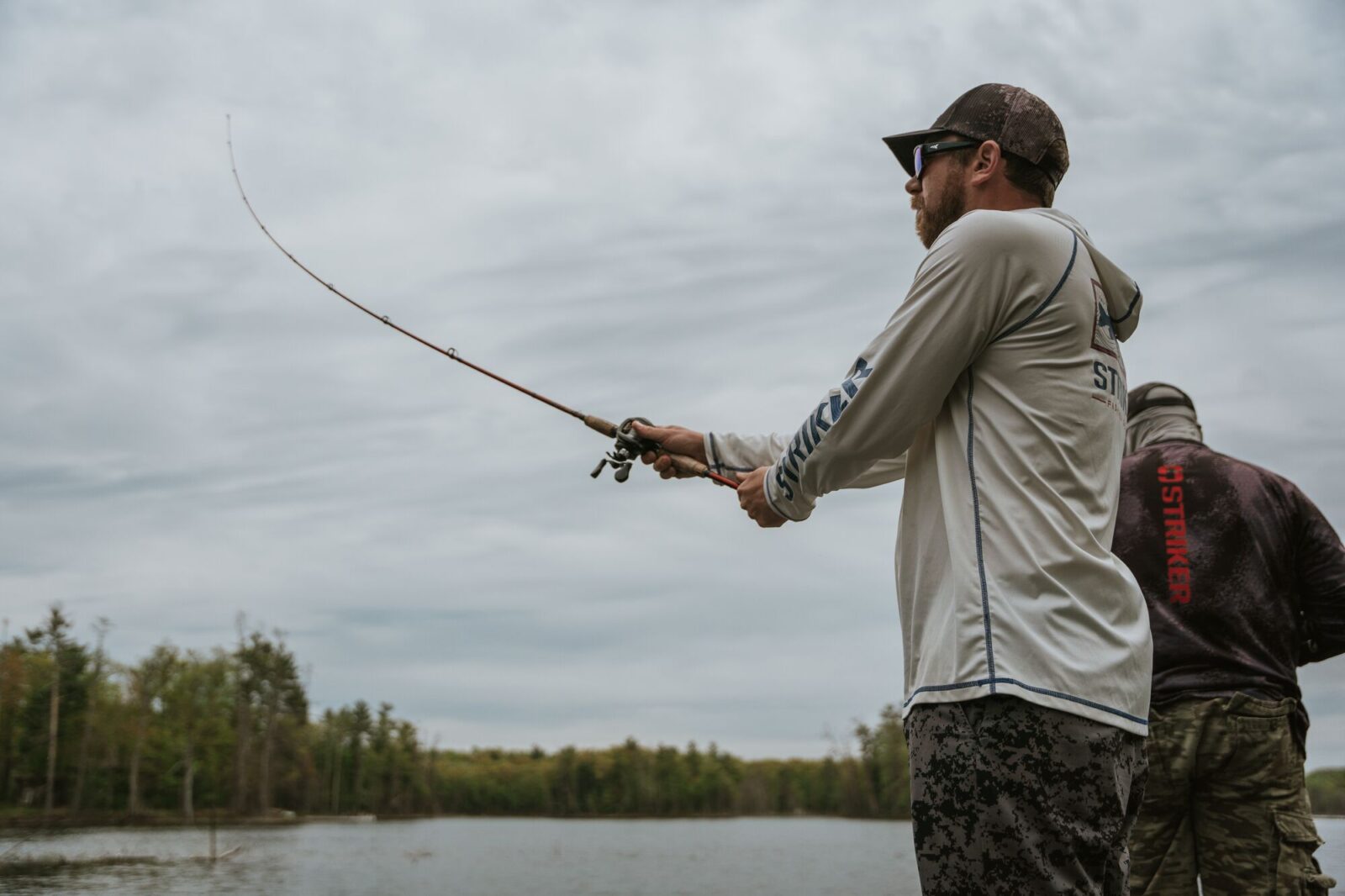 anglers fishing from a bank into a lake
