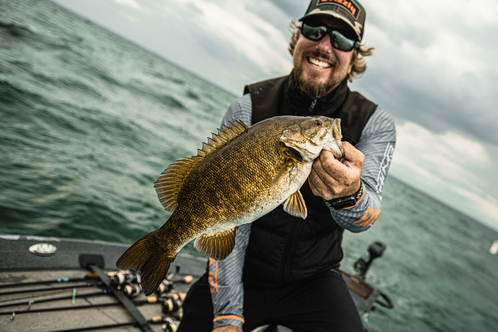 A fisherman holds the fish he caught up to the camera.