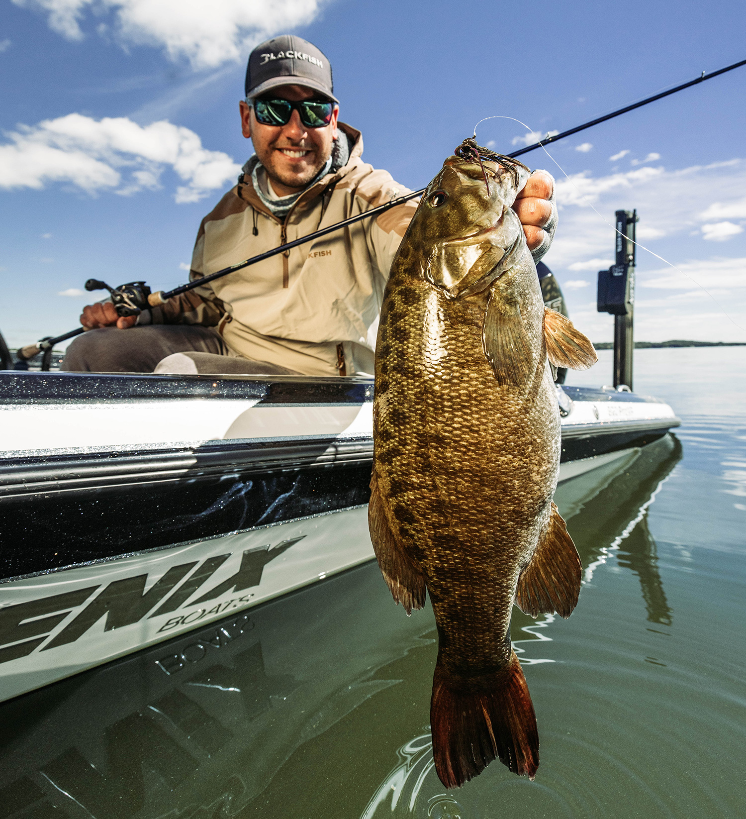 A person holds a smallmouth bass. 
