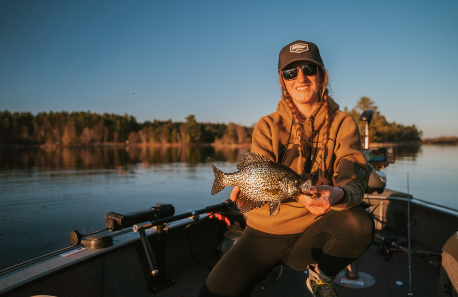 A female angler holds up a crappie she caught.