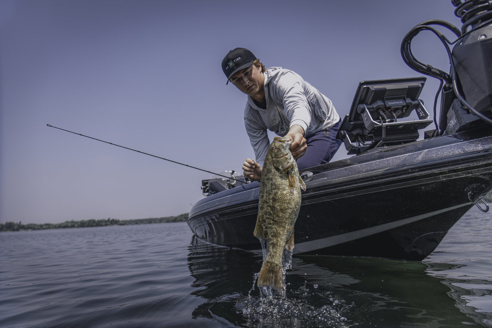 smallmouth bass being pulled up to a fishing boat