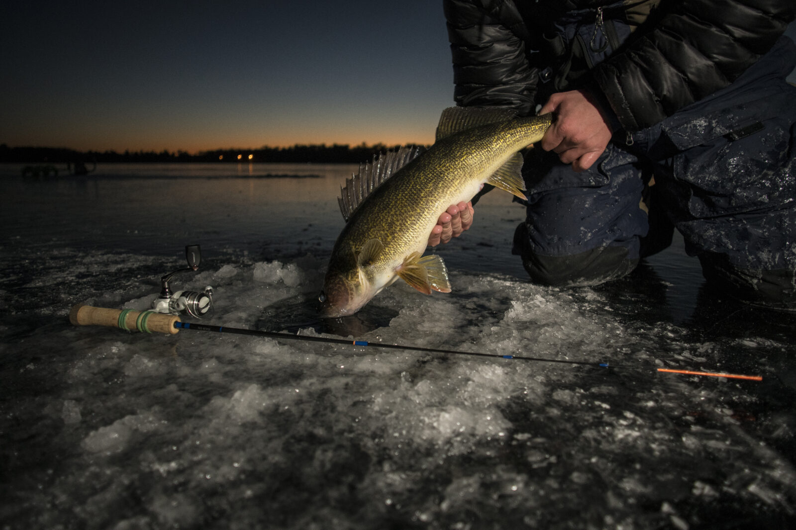 an angler night fishing on ice 