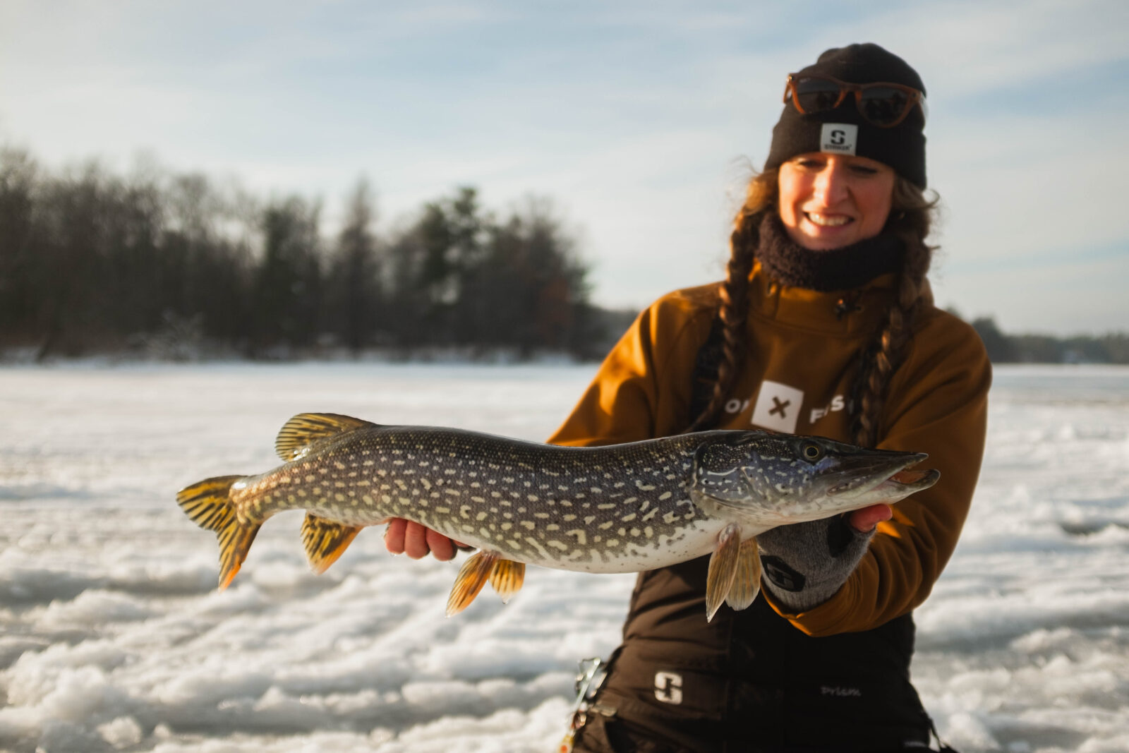 Woman ice fishing with a trophy walleye