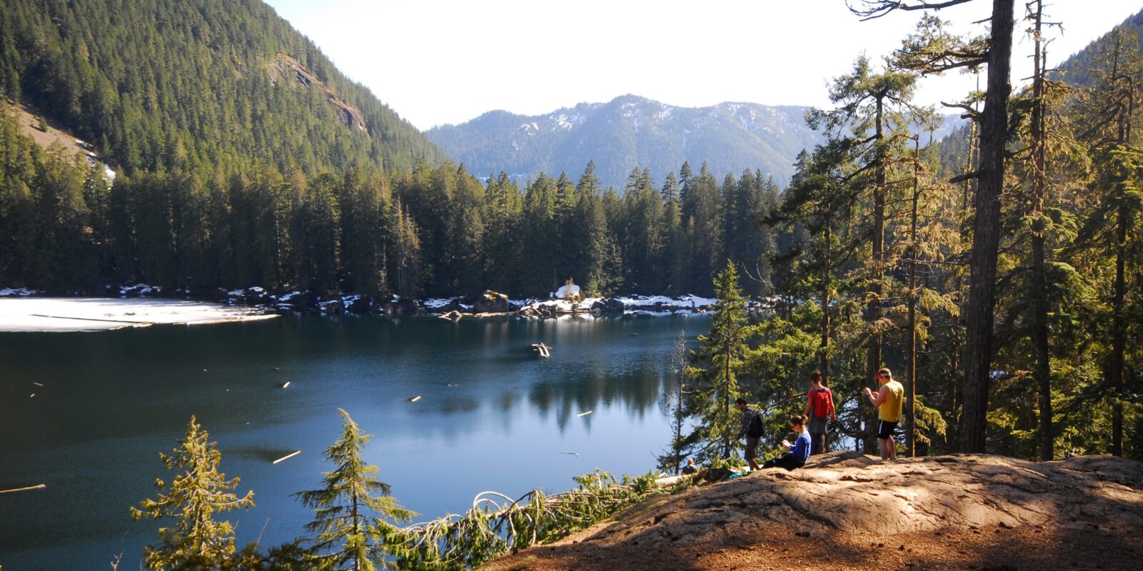 Backpackers hanging out by an ice and snow covered Lake Lena