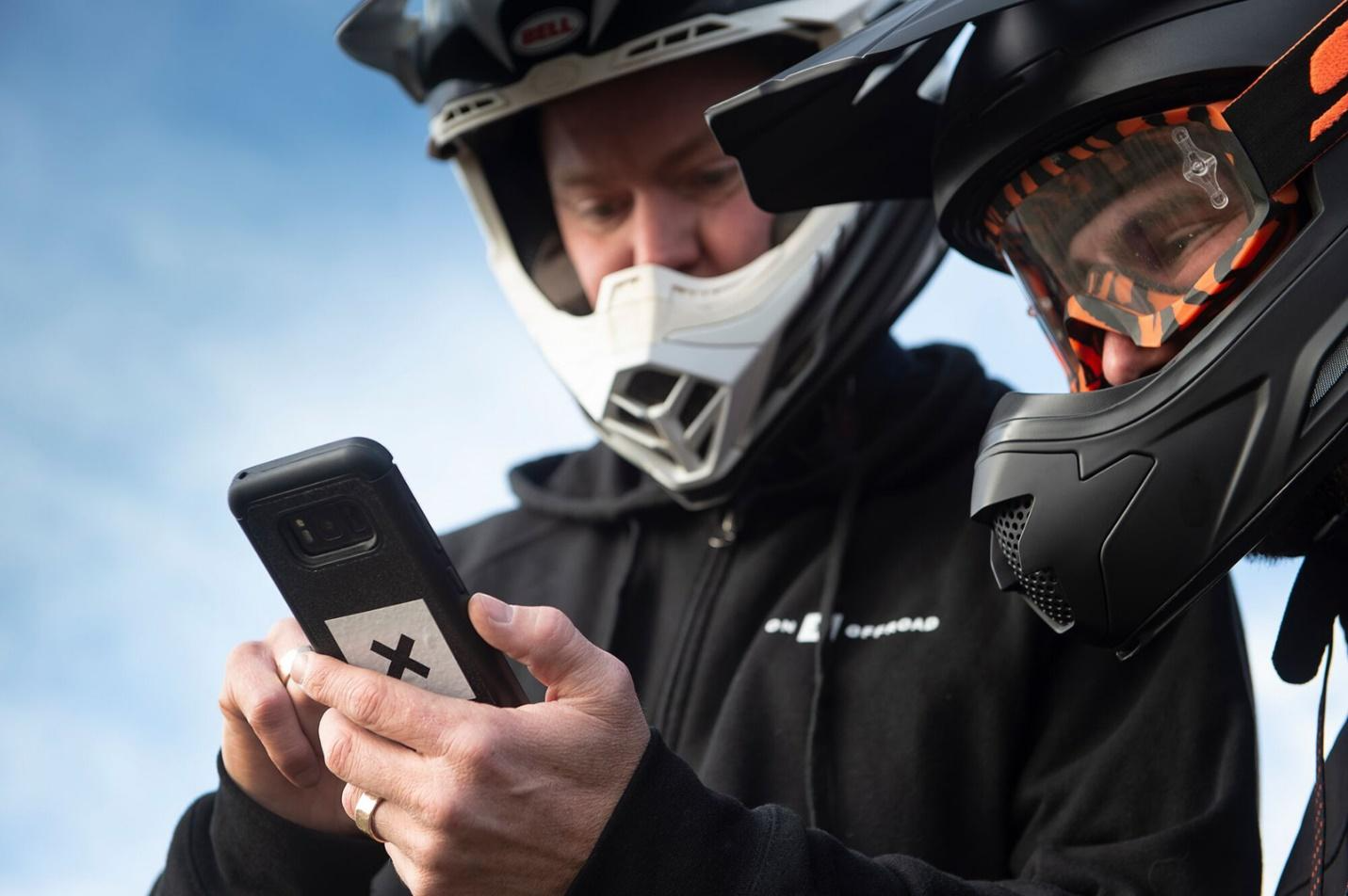 off-raoders in helmets looking at the onX Offroad app 
