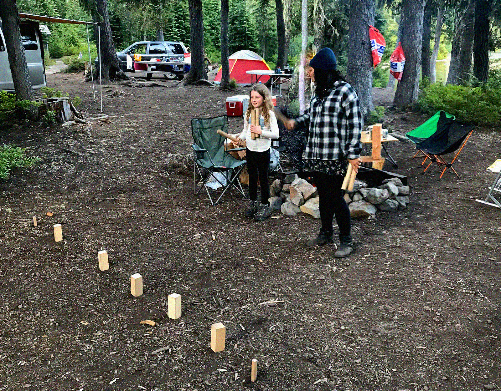 mother and daughter playing Kubb in a campground 