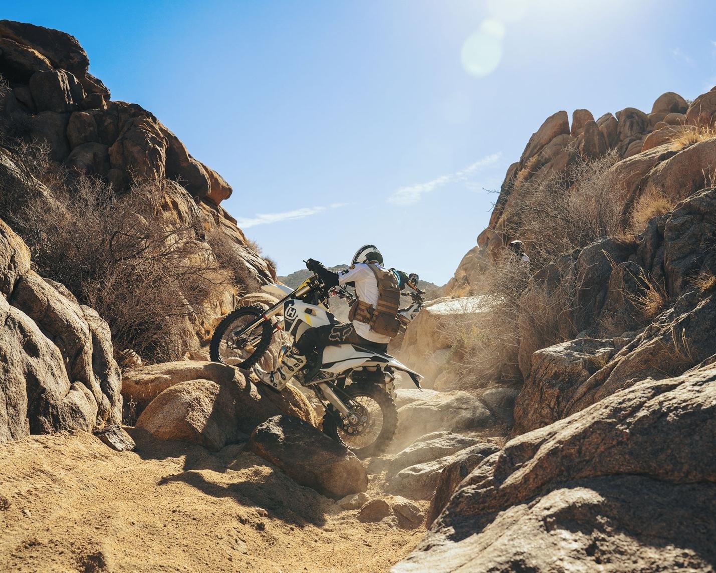 dirt biker going up a difficult rocky trail 
