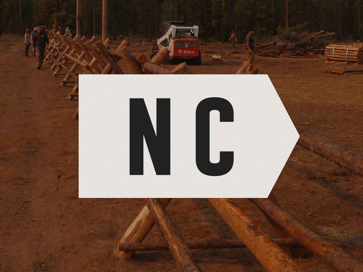 NC highlighted on a photo of onX Offroad Trail Revival Project volunteers working on repairing fences.